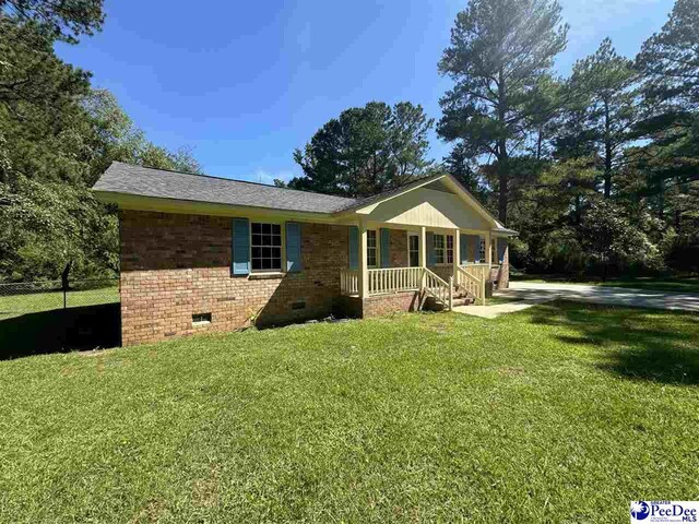 ranch-style home featuring a front yard and covered porch