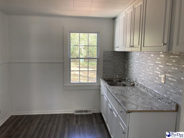 kitchen with a wealth of natural light, visible vents, decorative backsplash, and a sink