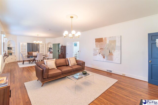 607 Third St, Cheraw, SC 29520 - living room featuring hardwood / wood-style flooring, ornamental molding, and a notable chandelier