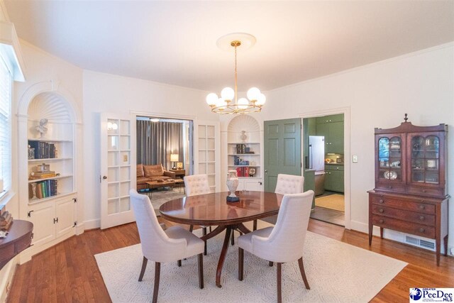 607 Third St, Cheraw, SC 29520 - dining space featuring hardwood / wood-style flooring, ornamental molding, and a chandelier