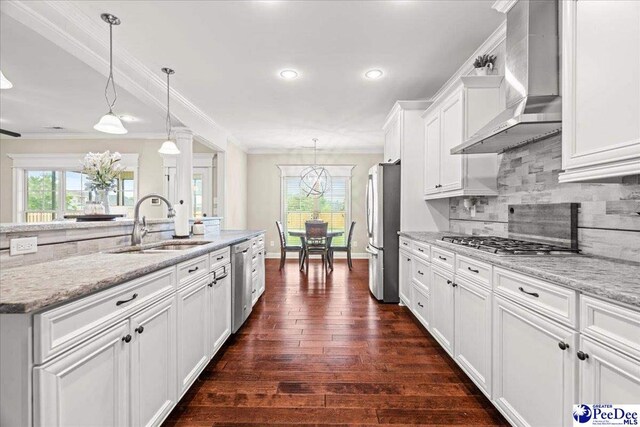 3106 Wainwright Ct, Florence, SC 29501 - kitchen featuring appliances with stainless steel finishes, wall chimney range hood, a sink, crown molding, and tasteful backsplash