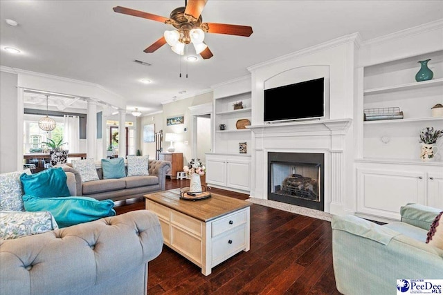 3106 Wainwright Ct, Florence, SC 29501 - living area featuring ornamental molding, a ceiling fan, dark wood-style floors, a fireplace with flush hearth, and built in shelves