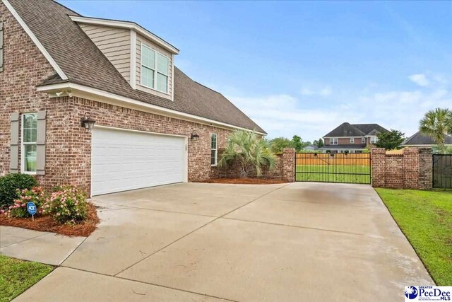 3106 Wainwright Ct, Florence, SC 29501 - view of side of property featuring brick siding, concrete driveway, an attached garage, and roof with shingles