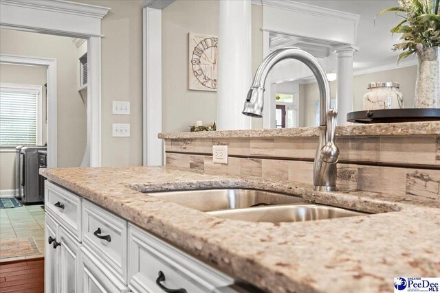 3106 Wainwright Ct, Florence, SC 29501 - kitchen with a sink, white cabinets, light stone countertops, crown molding, and plenty of natural light