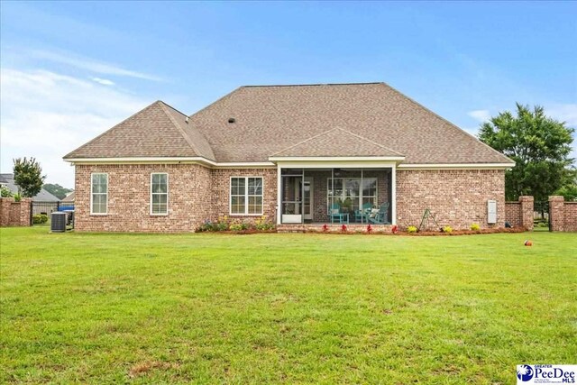 3106 Wainwright Ct, Florence, SC 29501 - rear view of property featuring a lawn, central air condition unit, a sunroom, and brick siding