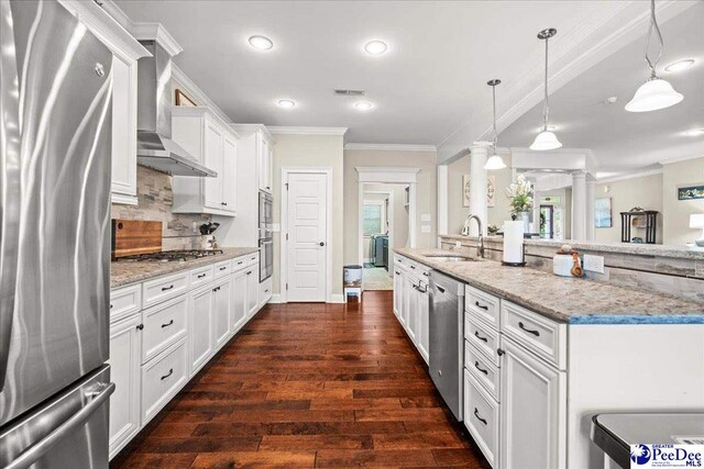 3106 Wainwright Ct, Florence, SC 29501 - kitchen featuring appliances with stainless steel finishes, a sink, wall chimney range hood, ornamental molding, and ornate columns