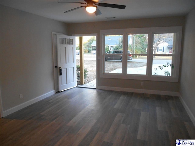 spare room featuring dark wood-type flooring and ceiling fan