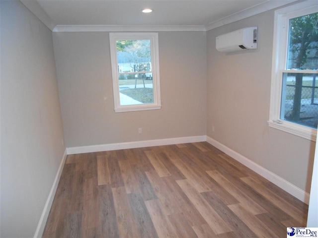 spare room with crown molding, hardwood / wood-style flooring, and an AC wall unit