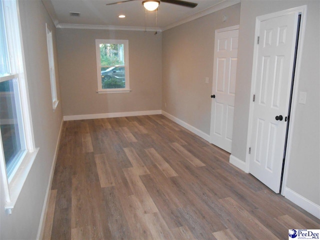 unfurnished room with crown molding, ceiling fan, and dark hardwood / wood-style flooring