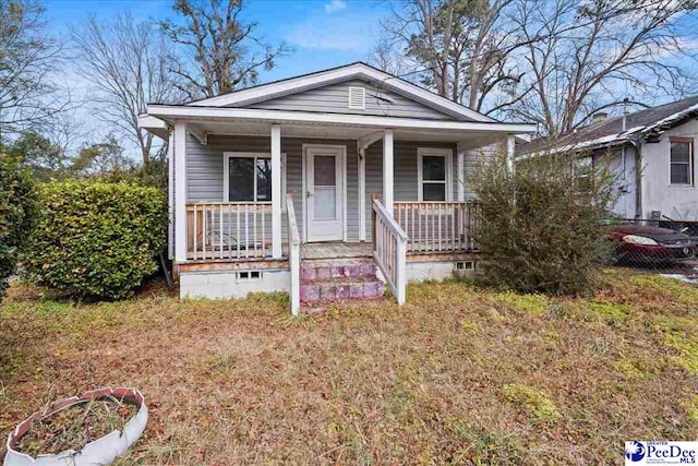 bungalow with a porch and a front lawn