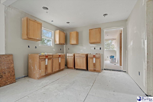 kitchen featuring a textured ceiling and light brown cabinetry