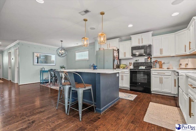 1200 Turtle Dove Dr, Effingham, SC 29541 - kitchen with black appliances, crown molding, a center island, white cabinetry, and a breakfast bar