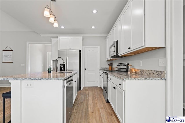 kitchen featuring a center island with sink, stainless steel appliances, white cabinetry, light wood-type flooring, and a kitchen bar