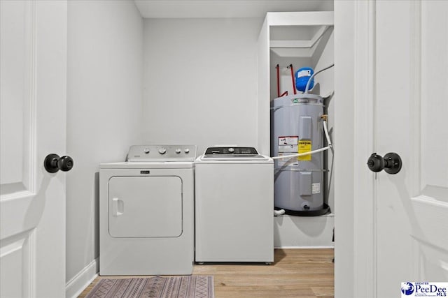 laundry room featuring electric water heater, baseboards, laundry area, light wood-style floors, and independent washer and dryer