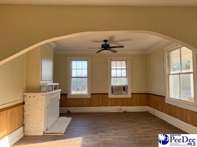 interior space featuring cooling unit, dark hardwood / wood-style flooring, ornamental molding, and ceiling fan