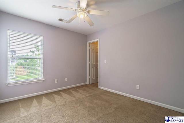 carpeted spare room featuring ceiling fan