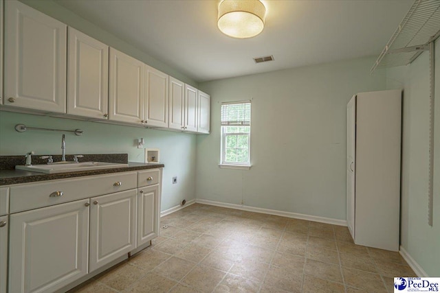 washroom with cabinets, washer hookup, hookup for an electric dryer, and sink