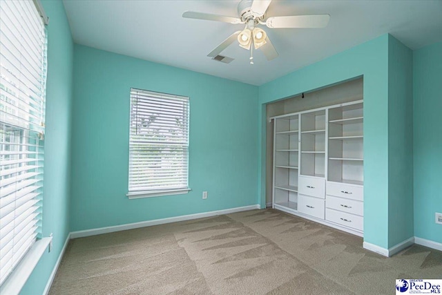 unfurnished bedroom with light colored carpet, ceiling fan, and a closet