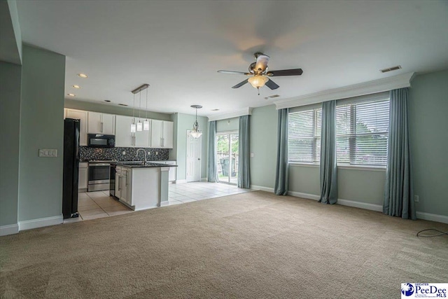 unfurnished living room featuring sink, light colored carpet, and ceiling fan