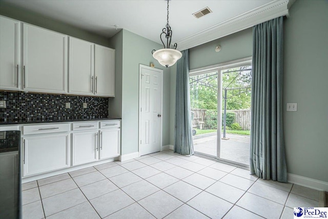 kitchen featuring hanging light fixtures, light tile patterned floors, dishwashing machine, white cabinets, and backsplash