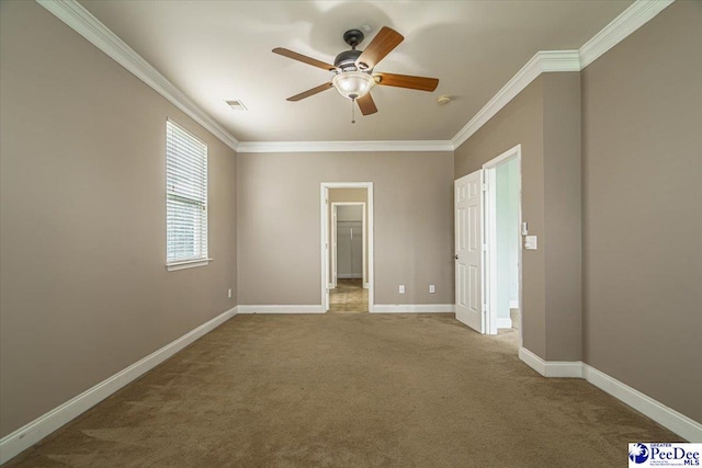 spare room featuring crown molding, carpet, and ceiling fan