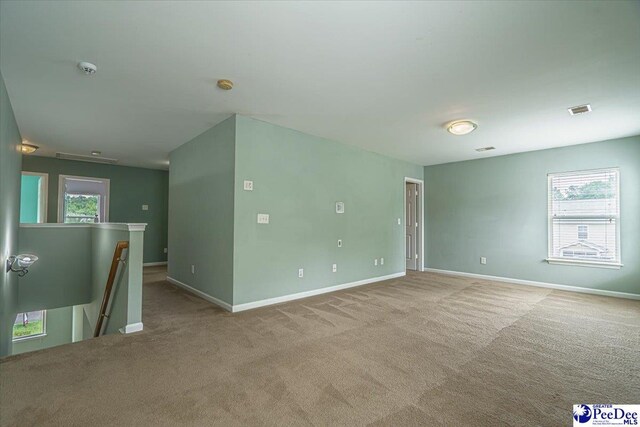 unfurnished room featuring a healthy amount of sunlight and light carpet