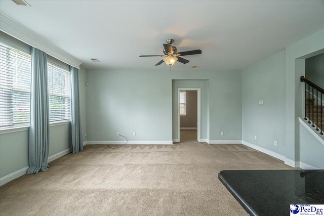 spare room with light colored carpet and ceiling fan