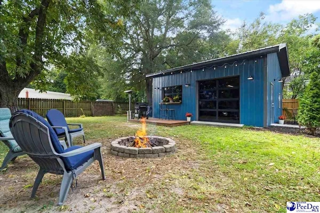 view of yard featuring an outdoor structure and a fire pit