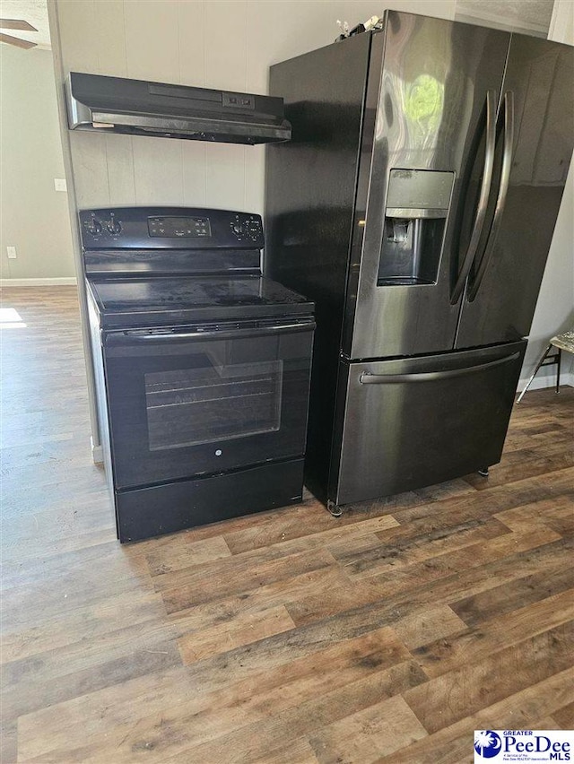 kitchen featuring under cabinet range hood, stainless steel fridge, black / electric stove, and wood finished floors