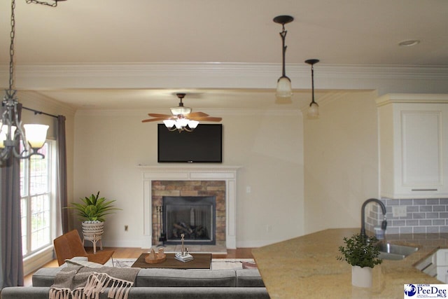 610 Garden Rose Ct, Greer, SC 29651 - living room with a fireplace, ornamental molding, ceiling fan, wood finished floors, and a chandelier