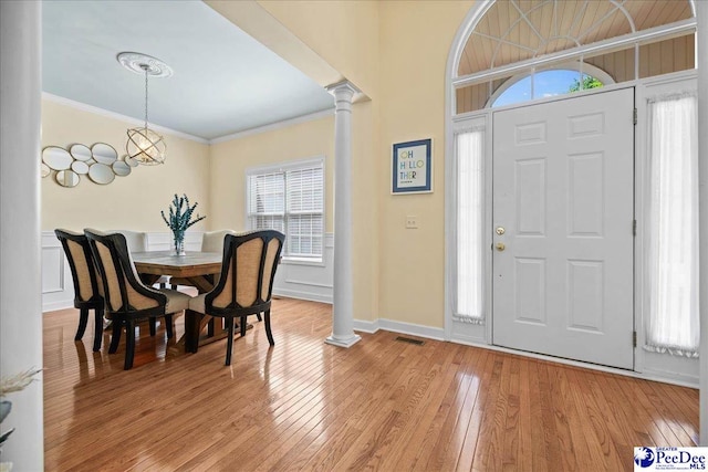 2819 Hermitage Ln, Florence, SC 29501 - entryway with ornate columns, light wood-style floors, crown molding, and baseboards