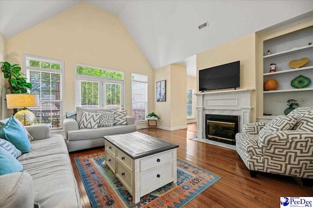 2819 Hermitage Ln, Florence, SC 29501 - living room featuring dark wood finished floors, a high end fireplace, high vaulted ceiling, and built in shelves