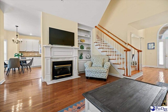 2819 Hermitage Ln, Florence, SC 29501 - living room with stairway, dark wood-style floors, a chandelier, baseboards, and a fireplace