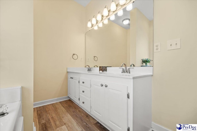 2819 Hermitage Ln, Florence, SC 29501 - bathroom featuring wood finished floors, double vanity, and baseboards