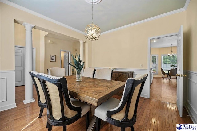 2819 Hermitage Ln, Florence, SC 29501 - dining area featuring a chandelier, hardwood / wood-style flooring, ornamental molding, a wainscoted wall, and ornate columns