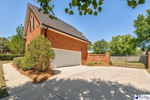 2819 Hermitage Ln, Florence, SC 29501 - view of side of property featuring concrete driveway, brick siding, fence, a shingled roof, and a garage