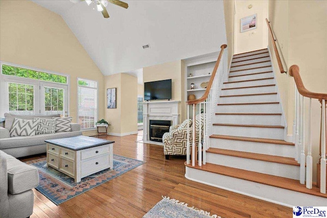 2819 Hermitage Ln, Florence, SC 29501 - living area featuring high vaulted ceiling, stairs, wood finished floors, a fireplace, and a ceiling fan