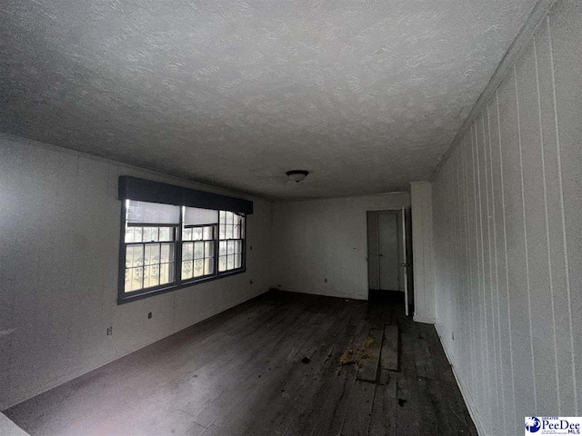 unfurnished room with dark hardwood / wood-style floors and a textured ceiling