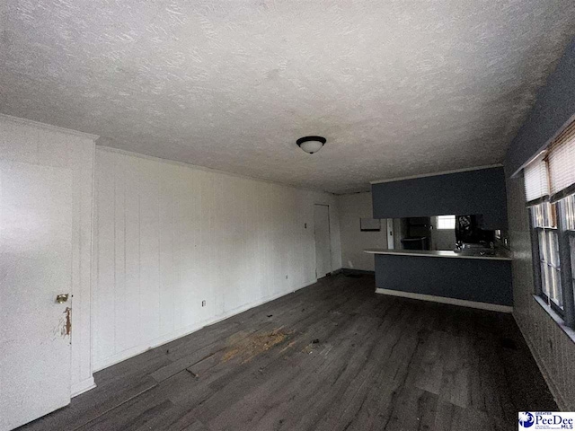 unfurnished living room featuring dark hardwood / wood-style flooring and a textured ceiling