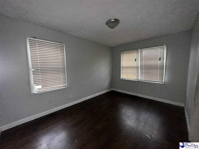 empty room featuring dark hardwood / wood-style flooring