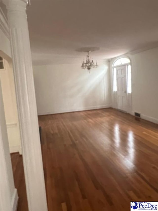 spare room with hardwood / wood-style floors and ornate columns