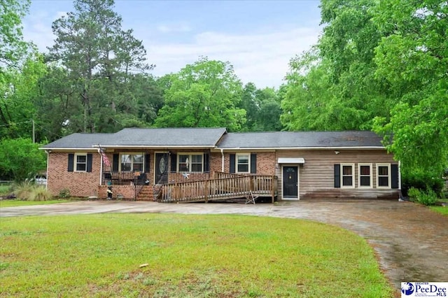 1017 Big Swamp Rd, Pamplico, SC 29583 - ranch-style home with a front lawn, curved driveway, brick siding, and covered porch
