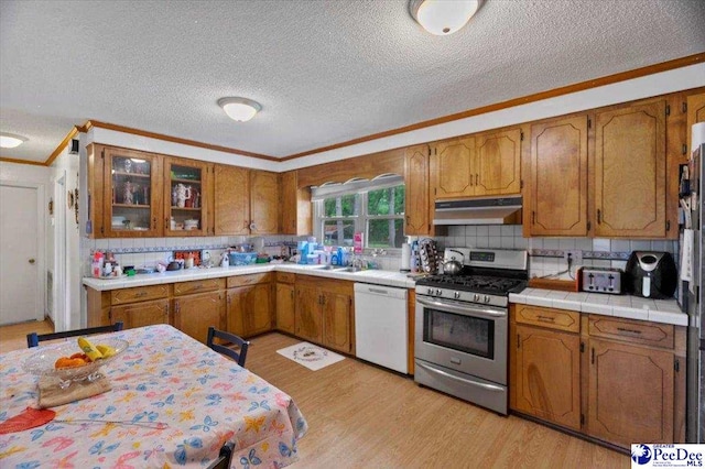 1017 Big Swamp Rd, Pamplico, SC 29583 - kitchen with dishwasher, gas range, crown molding, under cabinet range hood, and a textured ceiling