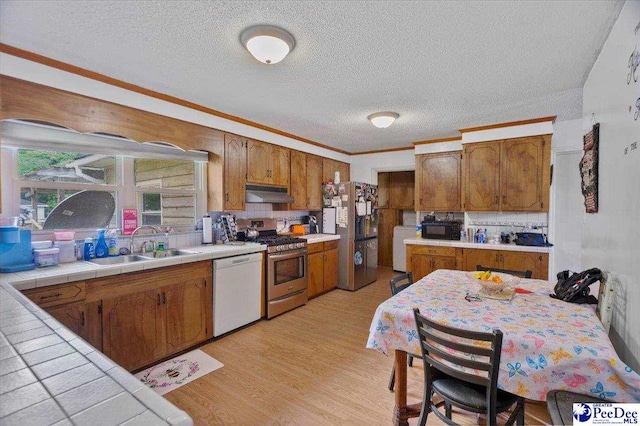 1017 Big Swamp Rd, Pamplico, SC 29583 - kitchen with appliances with stainless steel finishes, a sink, under cabinet range hood, a textured ceiling, and light wood finished floors