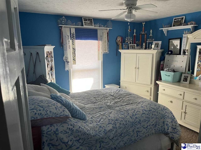 bedroom with ceiling fan and a textured ceiling