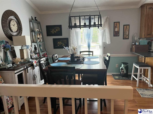 dining area with ornamental molding and hardwood / wood-style floors