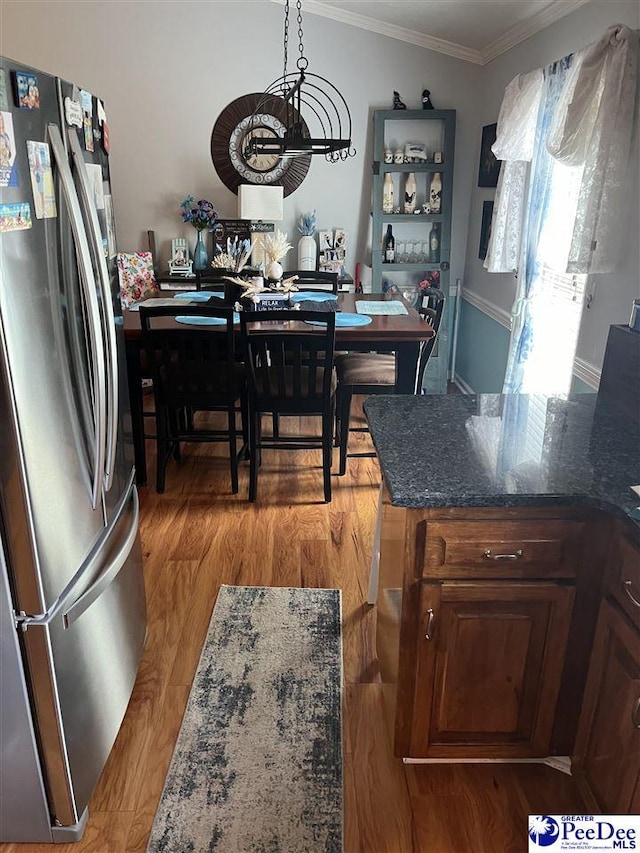 dining area featuring ornamental molding and light hardwood / wood-style floors