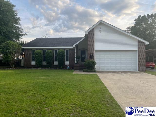 single story home with a carport, a garage, and a front yard