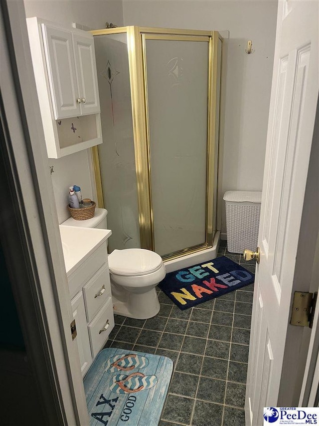 bathroom with vanity, toilet, tile patterned floors, and a shower with shower door