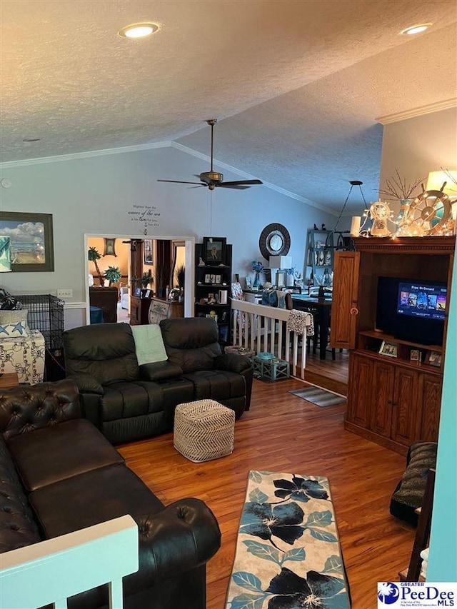 living room featuring hardwood / wood-style floors, crown molding, vaulted ceiling, and a textured ceiling